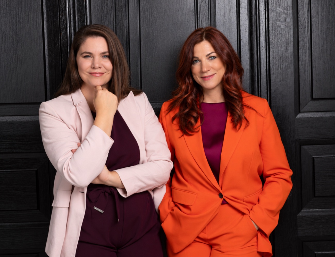 Die Gründerinnen der TALAVY Social Suite: Dunja Ellensohn im rosa Blazer und Nina Fleisch im orangen Anzug